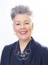Headshot of Helen Whiteman, CEO of CIOT, smiling in a navy blazer and silver necklace